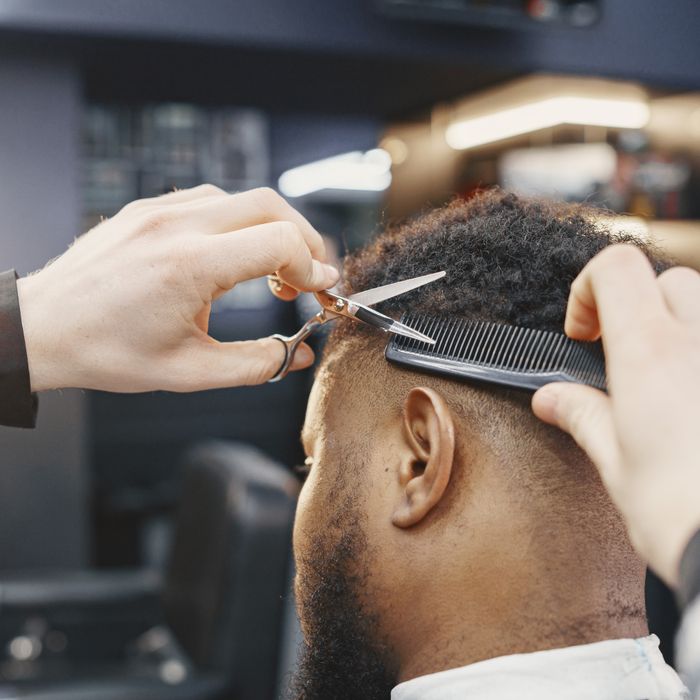 Barber wycina fade nożyczkami i grzebieniem